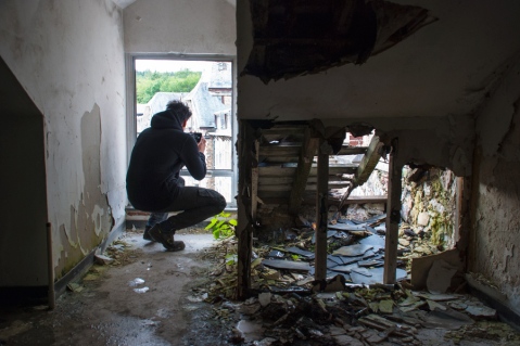 Urbexer Sandyp fotografeert vanuit een dakraam bij Sanatorium du Basil